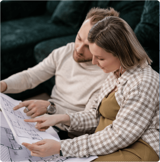 man and woman pointing to house plans