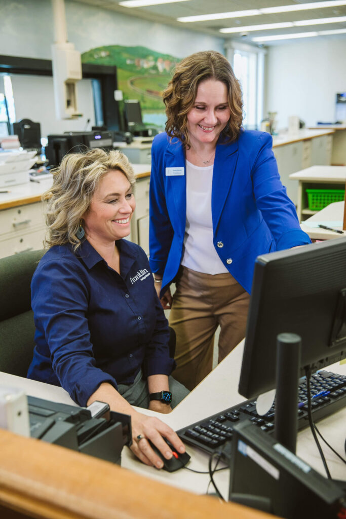 two bank employees at computer