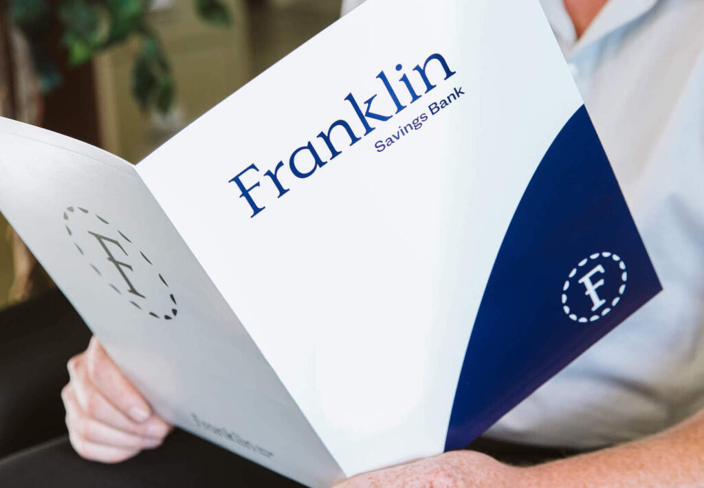 man holding franklin savings bank folder