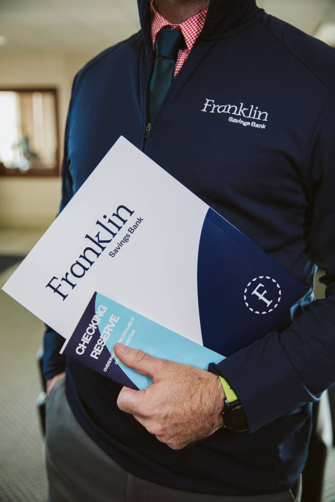 man holding franklin savings bank folder